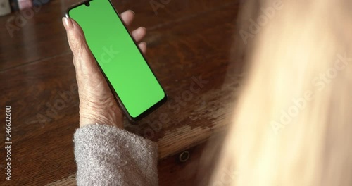green screen on the phone old hands of an elderly woman.