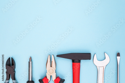 Various tools worker, hammer, wrench, screwdriver, pliers on a blue background, top view with free space photo