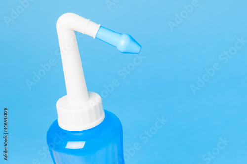 blue water pulse nasal wash bottle on a blue background, nasal irrigation concept