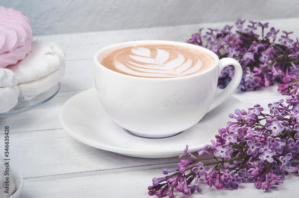 Lilac, coffee cup with latte art and marshmallow on white wooden table. Flat lay Lilac, coffee cup with latte art and marshmallow on white wooden table. Flat lay