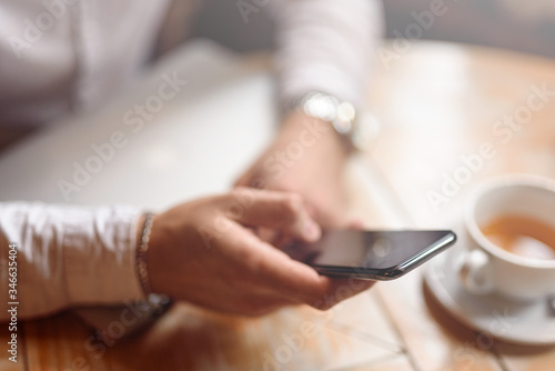 Cropped photo of male hands with smartphone