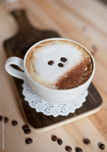A cup of cappuccino with coffee beans 