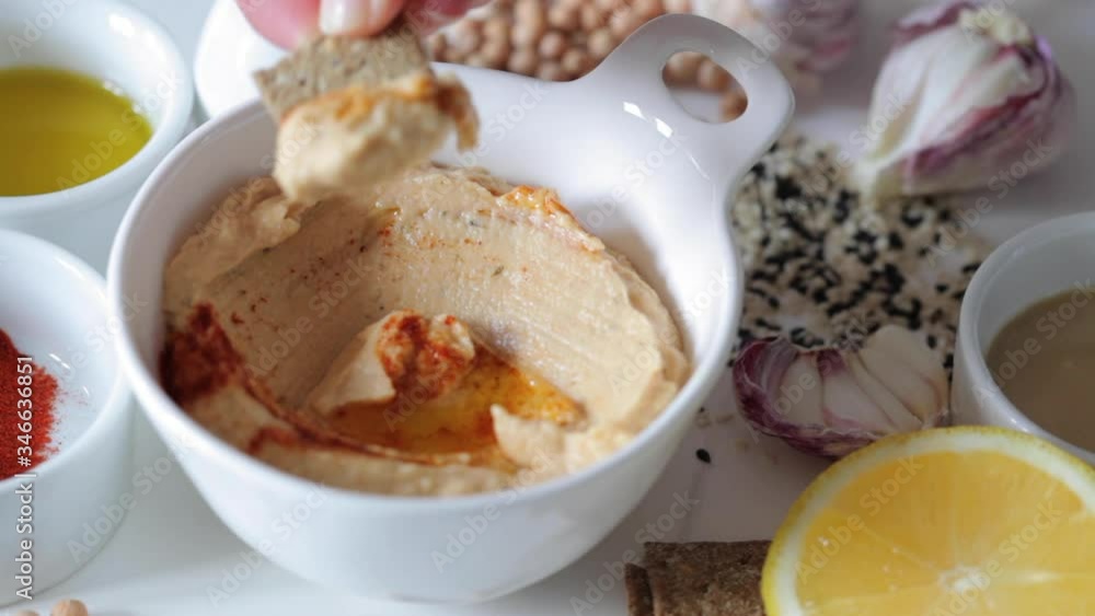 Homemade traditional hummus with ingredients.Mini crisp bread to dip in hummus bowl. Homemade traditional hummus with ingredients.Mini crisp bread to dip in hummus bowl.