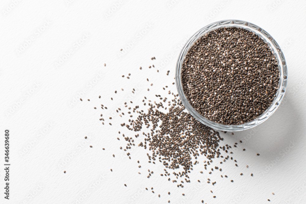 Chia seeds in a cup beautifully laid out on a white background. Top view. copy space.. Vegetarian food. Chia seeds in a cup beautifully laid out on a white background. Top view. copy space.. Vegetarian food.