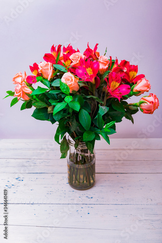 Colorful bouquet of different fresh flowers against brick wall. Bunch of roses, freesia and eucalyptus leaves. Rustic flower background. Top view