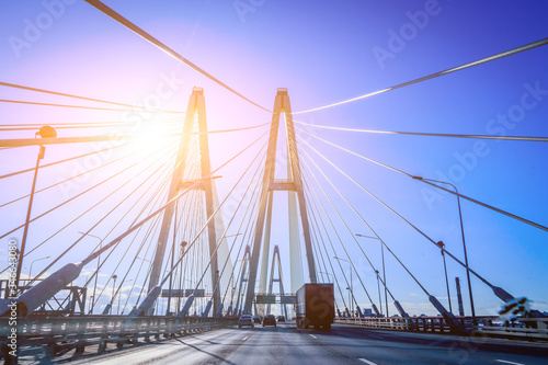 Cable-stayed bridge on a sunny day. Road for cars through the railway. Travelling by car. City business trips. Traffic on the roads.