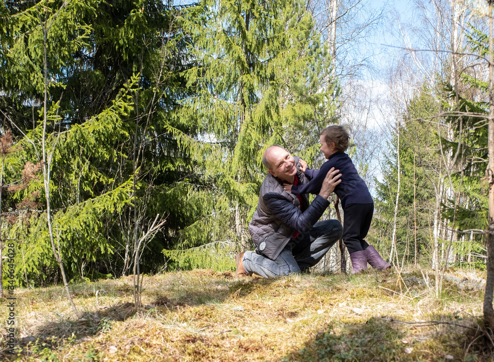 Walk in the woods. Dad and daughter have fun in a forest glade, a girl laughs and plays happily with a man Walk in the woods. Dad and daughter have fun in a forest glade, a girl laughs and plays happily with a man