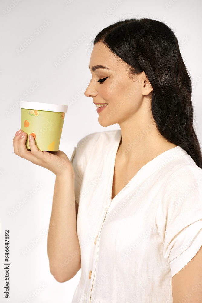 Cheerful girl holding a colored paper tray. Studio portrait. Cheerful girl holding a colored paper tray. Studio portrait.