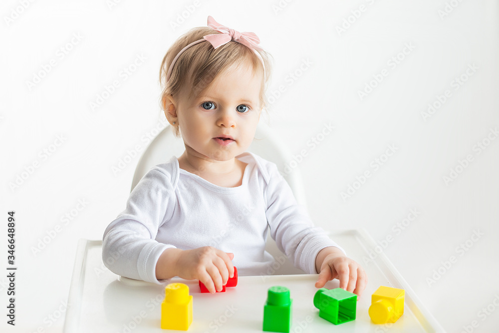 Cute baby girl playing with colorful toy blocks. Little child building tower at home. Educational toys for young children. Construction block for toddler kid. Cute baby girl playing with colorful toy blocks. Little child building tower at home. Educational toys for young children. Construction block for toddler kid.