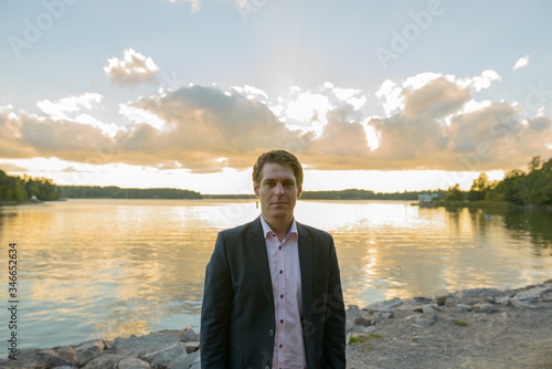 Young handsome businessman in front of beautiful scenic shore