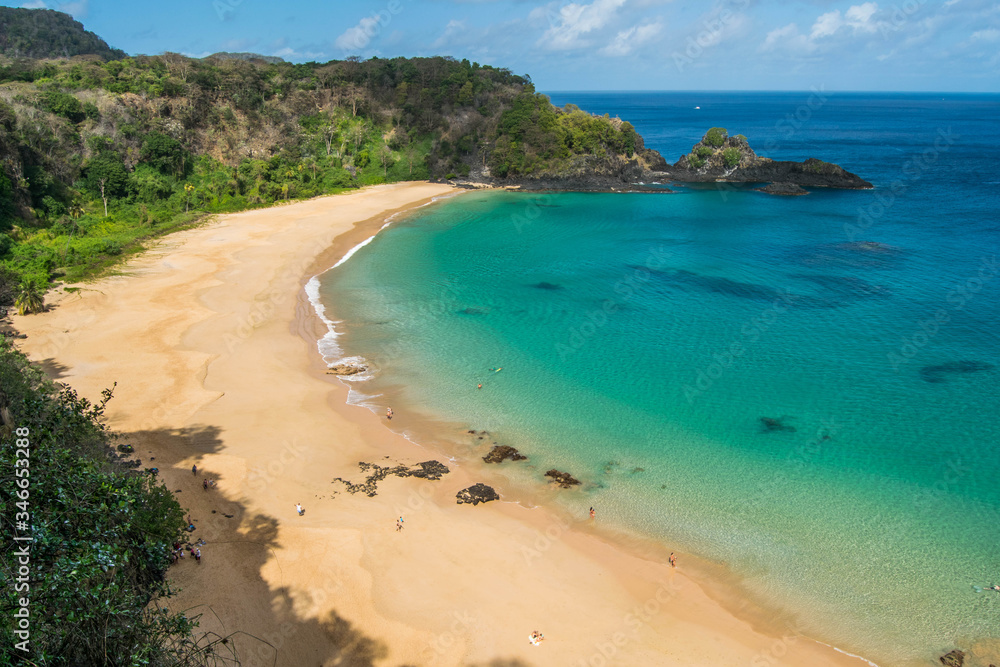 Fototapeta premium Panoramic view of Sancho Beach and Sancho bay, Fernando de Noronha Island, Brazil. Natural beach with trees and plants around