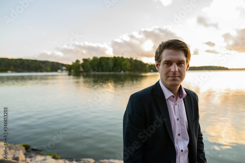 Young handsome businessman in front of beautiful scenic shore