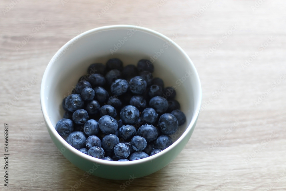 Bowl of fresh blueberries on a table. Selective focus. Bowl of fresh blueberries on a table. Selective focus.
