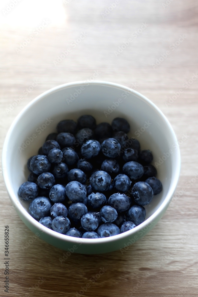 Bowl of fresh blueberries on a table. Selective focus. Bowl of fresh blueberries on a table. Selective focus.
