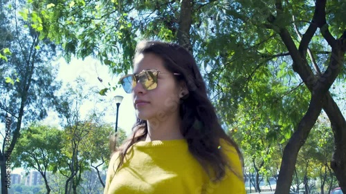 Beautiful woman with sunglasses walking on the street on a sunny day. Girl come out after the quarantine