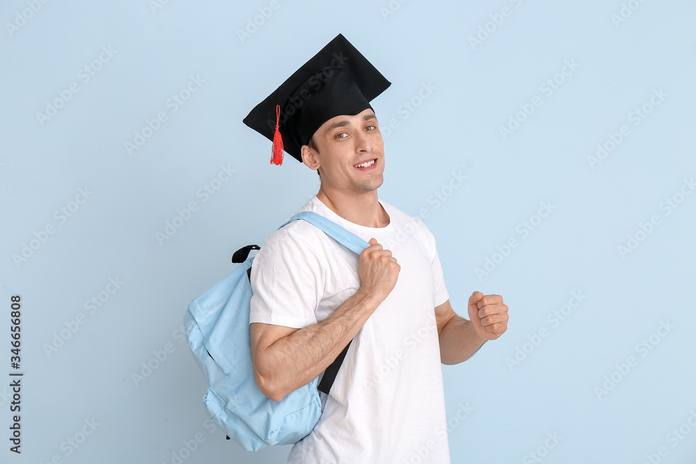 Young man in graduation hat on light background Young man in graduation hat on light background