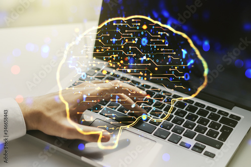 Double exposure of creative artificial Intelligence symbol with hands typing on laptop on background. Neural networks and machine learning concept