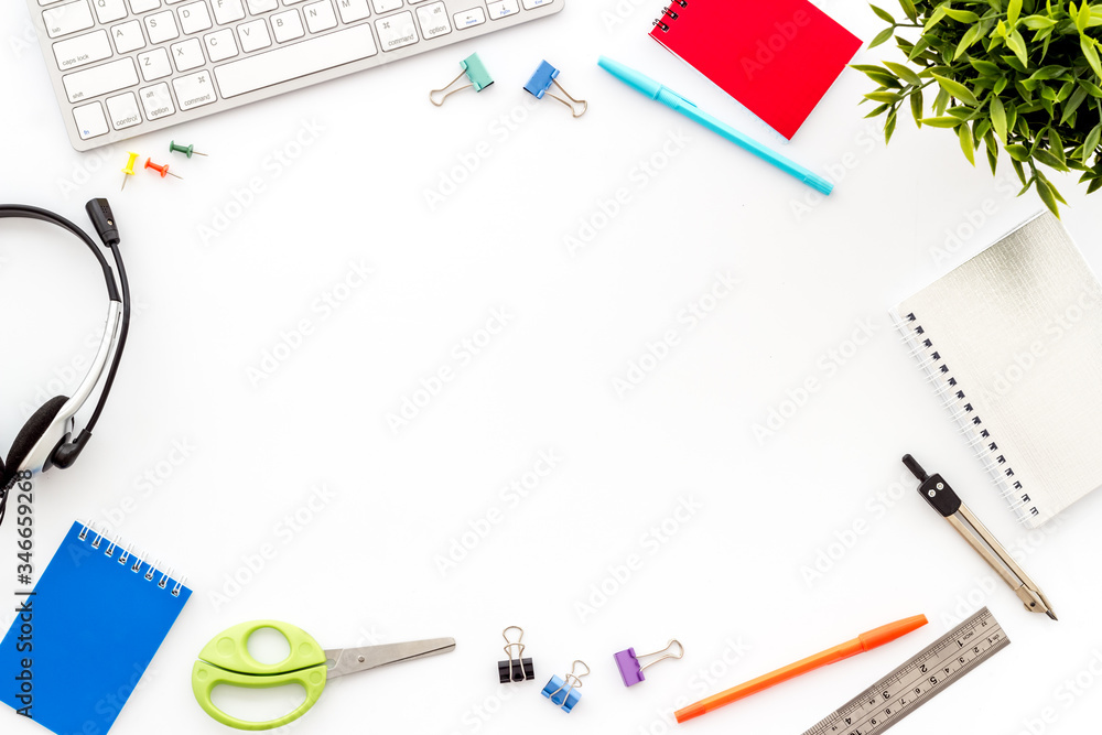E-learning. Stationery, headphones and keyboard on white table top-down frame copy space E-learning. Stationery, headphones and keyboard on white table top-down frame copy space