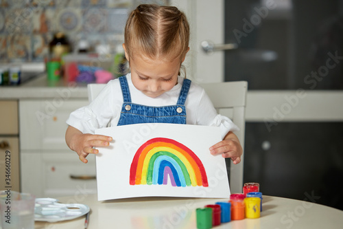 Thank to NHS. Kid painting the rainbow during Covid-19 quarantine at home. coronavirus covid-19 outbreak. photo
