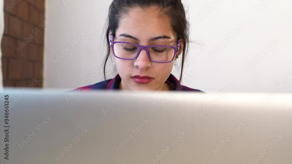 Attractive woman with glasses working on a computer she start to stress out Attractive woman with glasses working on a computer she start to stress out