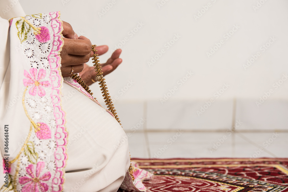 Muslim woman praying close up image of hands as she holds prayer beads ...