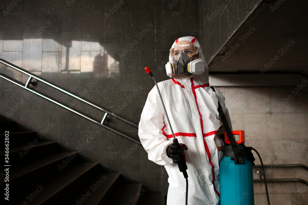 portrait of a disinfection service worker in a protective suit and a respirator against a city background, a sanitary worker,