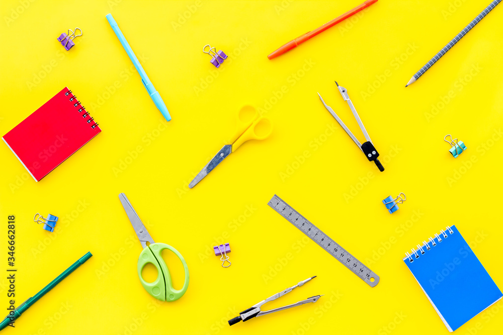 Flat lay stationery set - notebook, pen, sciccors - on yellow background top view Flat lay stationery set - notebook, pen, sciccors - on yellow background top view