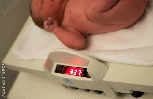 Obraz na płótnie Newborn baby at hospital is getting measured and weight in hospital and checked with Apgar scale after being born with no complications. Healthy caucasian baby with normal weight. w salonie