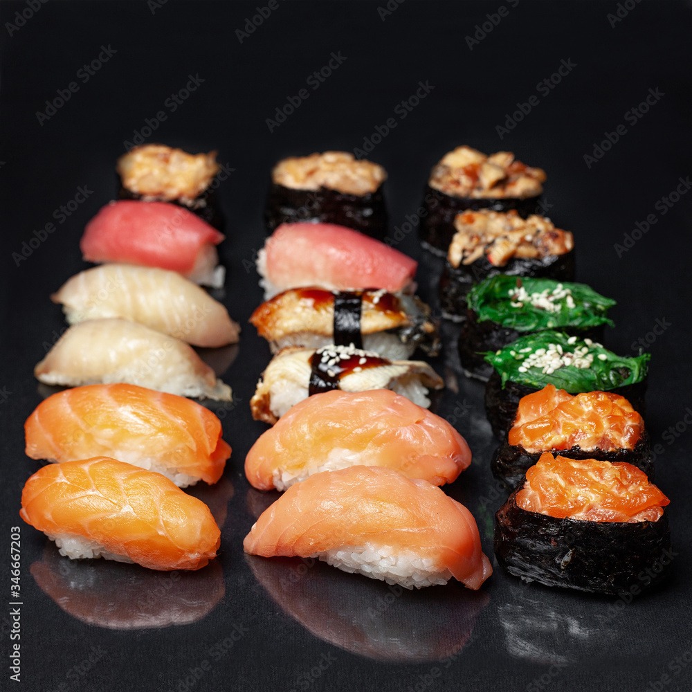 diverse delicious sushi roll set on a black background with reflection, menu