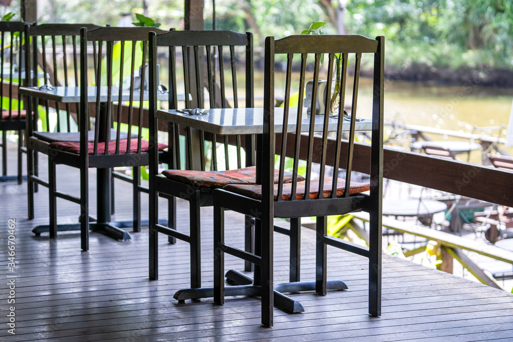 Chairs and table on the backyard in tropical cafe near lake with beautiful view Chairs and table on the backyard in tropical cafe near lake with beautiful view