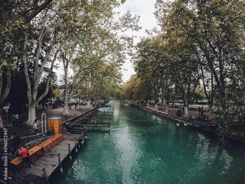 Vassé canal and its moored boats, banks and lines of plane trees in autumn. Canal du Vasse as seen from Pont des Amours. Located in the Auvergne-Rhône-Alpes region, France.