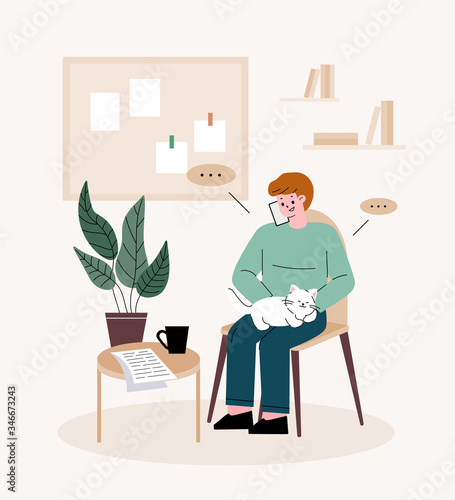 Man freelancer. Man holding a cat, talking on the phone. Telecommuting at home.