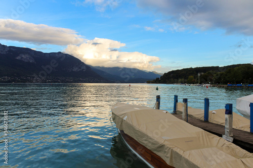 Bank of the Europe gardens, moored boats, Annecy lake and mountains mountain of La Tournette and the sharp rocky ridges of the Dents de Lanfon, Annecy, France. © An Instant of Time