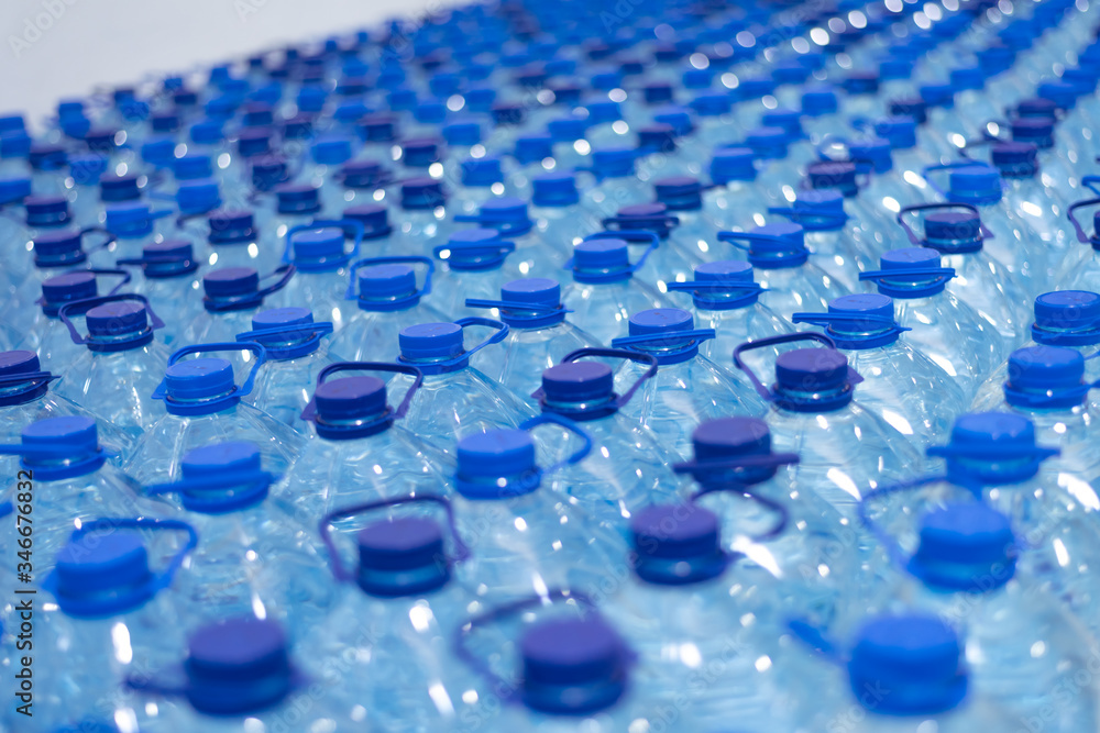 Lot of bottles worth with clean cool natural water. Group of plastic bottles with water stand in a row. Lot of bottles worth with clean cool natural water. Group of plastic bottles with water stand in a row.