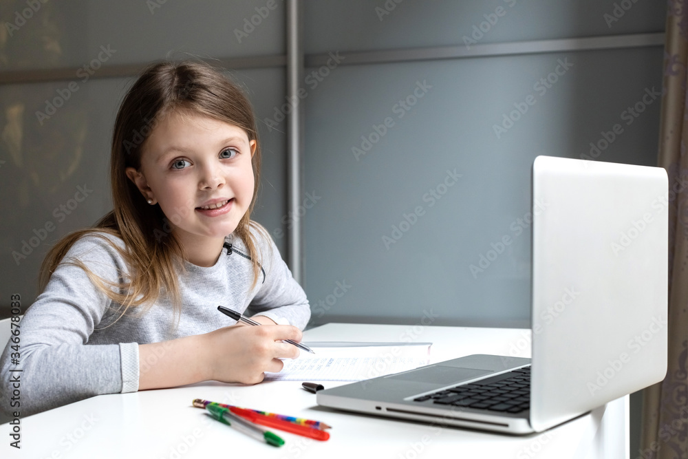 Schoolgirl doing her homework with laptop computer at home. Child using gadgets to study. Homeschooling, distance learning, home schooling, studying online education during the quarantine. Schoolgirl doing her homework with laptop computer at home. Child using gadgets to study. Homeschooling, distance learning, home schooling, studying online education during the quarantine.