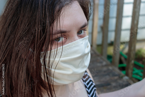 young woman with dark hair in face mask for protection