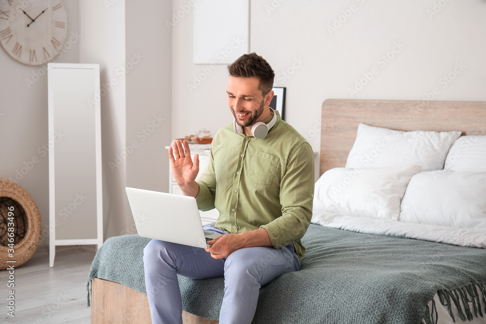 Young man video chatting at home