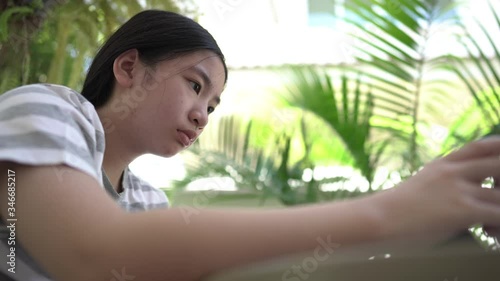 Asian girl doing homework to sent teacher at home