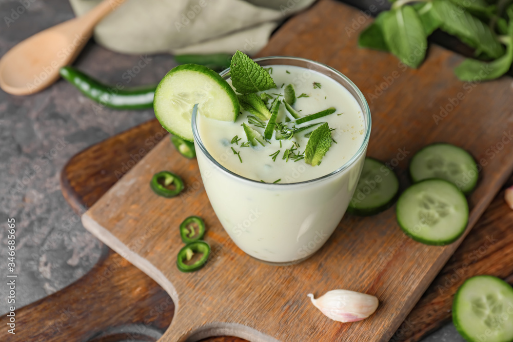 Glass with cold cucumber soup on table Glass with cold cucumber soup on table