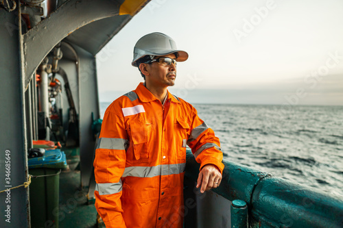 Papier peint Filipino deck Officer on deck of vessel or ship , wearing PPE personal protective equipment - helmet, coverall, lifejacket, goggles