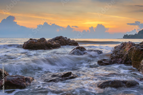 Morning scenery with beautiful skies on the coast with waves lapping against the rocks © nakhonthesis