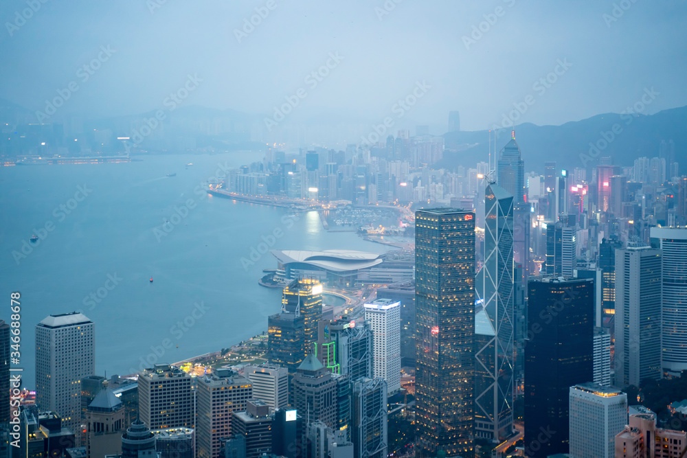 Lugard Road, Hoang Kong - January 1, 2020: Aerial view of Hong Kong city skyline during misty and hazy sunset.