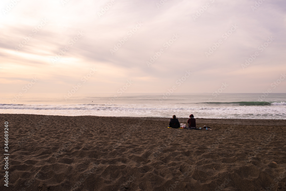 Two people enjoying beautiful sunset over Pacifica, San Mateo county, California