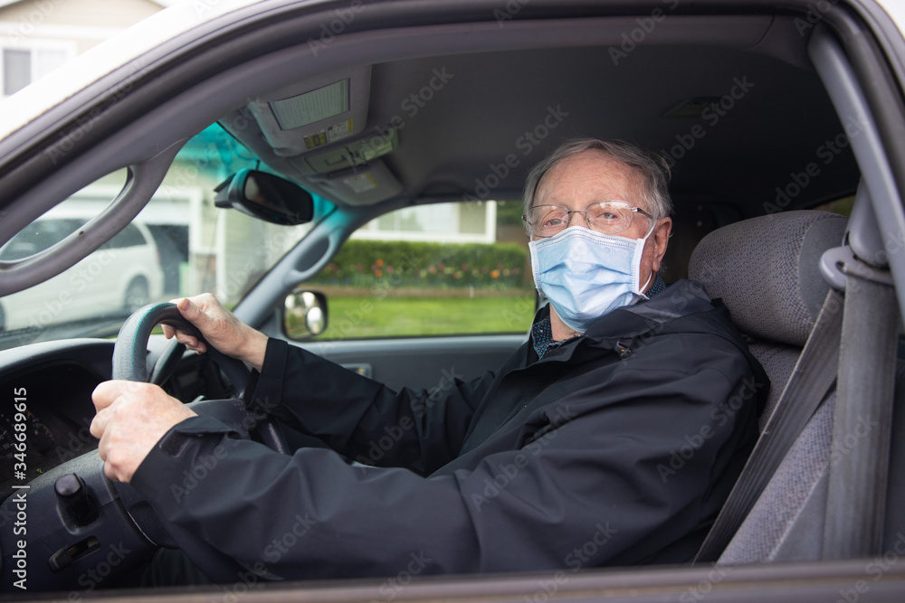 Senior citizen mature man driving while wearing medical mask to prevent covid-19 coronavirus infection Senior citizen mature man driving while wearing medical mask to prevent covid-19 coronavirus infection