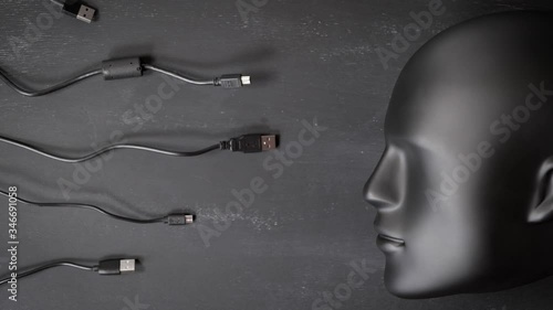 Artificial intelligence, futuristic cyborg concept in total black color. Many digital device wires cables chargers trying to connect to robot android head. Digitalization, chipization. Stop motion. photo