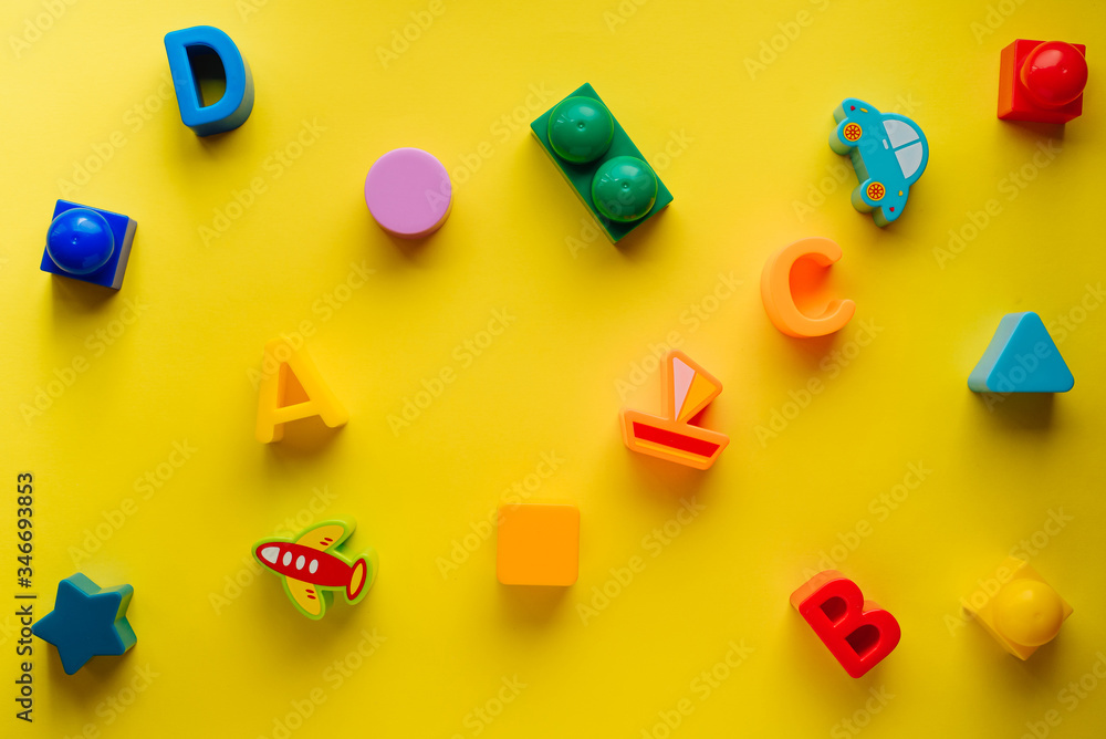 Top view on children s toys on a yellow background. Children's toys on the table. concept for advertising toys for children. Copy space children's toy. Top view on children s toys on a yellow background. Children's toys on the table. concept for advertising toys for children. Copy space children's toy.