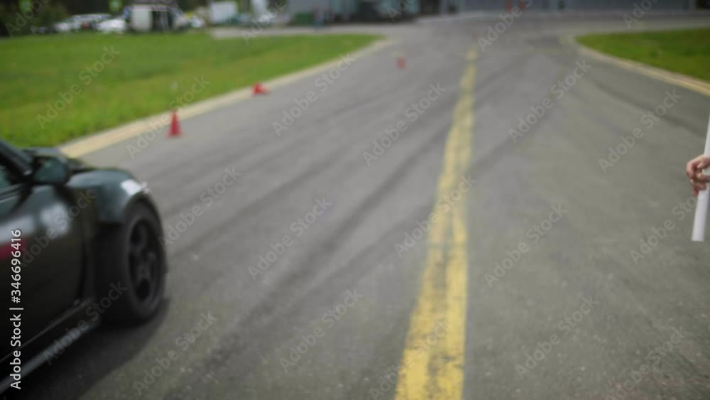 Man makes three swing with a yellow flag and race car breaks off from the start Man makes three swing with a yellow flag and race car breaks off from the start
