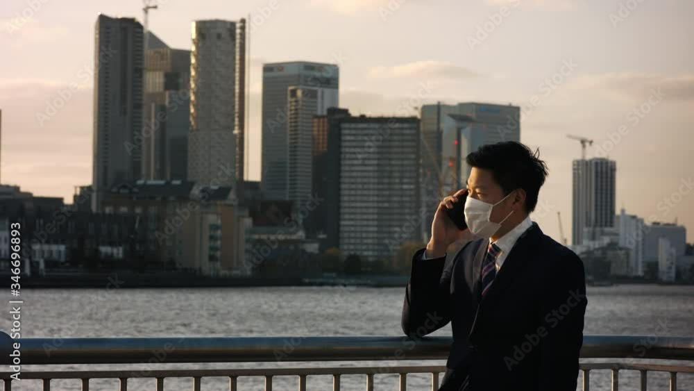 Asian man talking on phone during Coronavirus pandemic Asian man talking on phone during Coronavirus pandemic