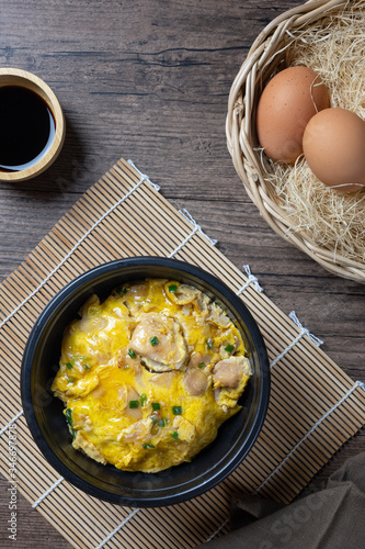 Oyako-don rice bowl topped with chicken, onions and egg cooked with special sauce. oyakodonburi Japanese food on wooden background. top view. Flat lay.