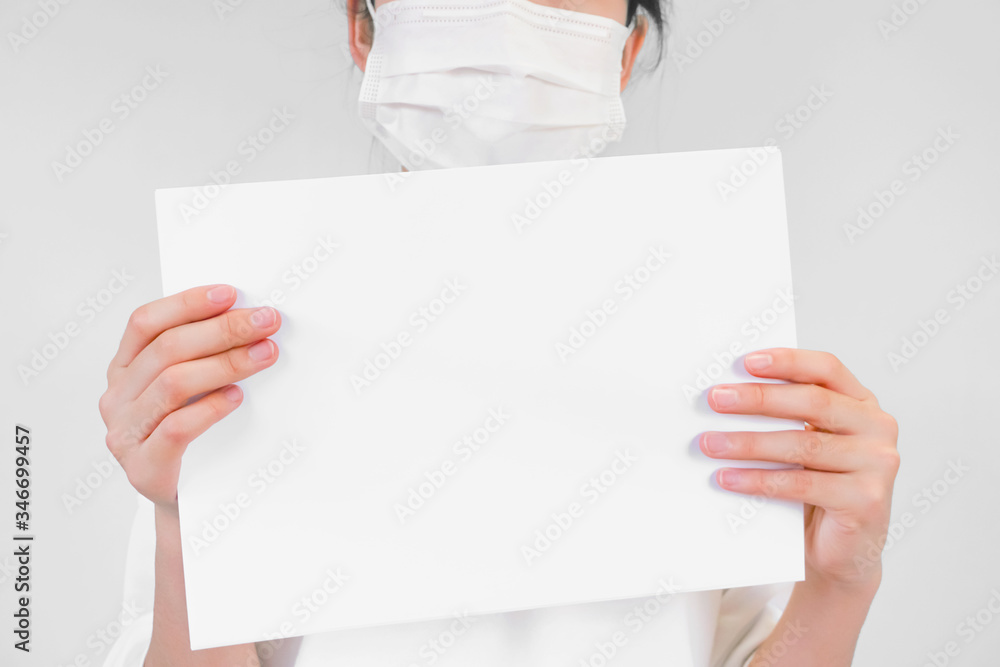 The person putting on a face mask holds the message board. マスクをつけた人が掲示板を持っている The person putting on a face mask holds the message board. マスクをつけた人が掲示板を持っている